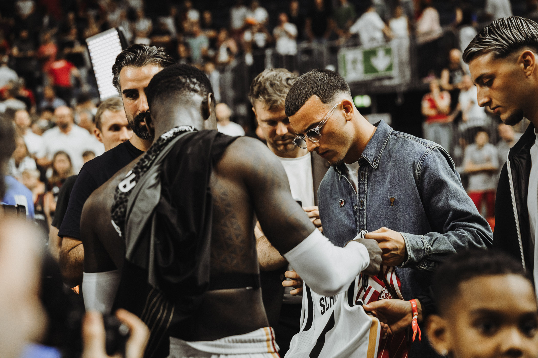 Dennis Schröder und Said El Mala bei einer Trikotübergabe in der LANXESS arena in Köln